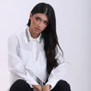 White ruffled blouse with embellished collar and button-down front.
